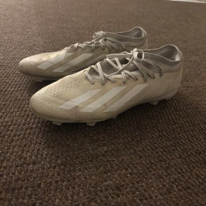 Vita fotbollsskor från Adidas - Säljer ett par stilrena vita fotbollsskor från Adidas med vita detaljer och snörning. Perfekta för fotbollsplanen med sin smidiga passform och greppvänliga sula. Dessutom så är dom ganska små i storleken. Mycket använda men är ändå i relativt skick!                                                         Tveka inte av att höra av er om ni har några funderingar och pris kan diskuteras💪