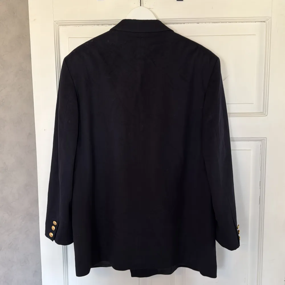 En klassisk dubbelknäppt blazer med fina guldfärgade knappar. 75% virgin wool och 25% cashmere blend från Loro Piana. Fickor framtill och innanför. Kavajen utstrålar massvis med elegans.. Puvut & Bleiserit.