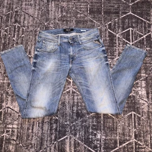 Blå jeans från Replay - Snygga blå jeans från Replay i modellen Anbass. De har en klassisk femficksdesign och en knappgylf. Perfekta för en avslappnad stil.