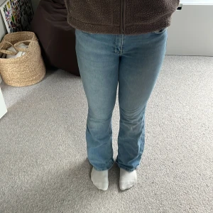 Ljusblå bootcut jeans - Snygga ljusblå bootcut jeans med en klassisk femficksdesign. De har en normal passform och är perfekta för en avslappnad stil. Jeansen har en knapp och dragkedja framtill. De är för stora för mig därför säljer jag dem