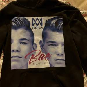 Säljer en svart hoodie med stort tryck av Marcus & Martinus på framsidan. Väldigt skönt material och skön passform. Köpt på amazon 