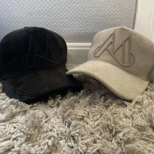 Svart och beige keps från Maggiore - Två stilrena kepsar från Maggiore i svart och beige. Båda kepsarna har en broderad logotyp framtill och justerbar passform. Perfekta för en avslappnad look. Köp två för 400 annars 250 kr styck.