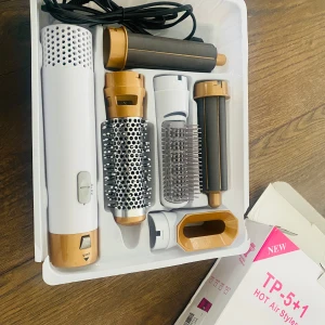TP-5+1 Hot Air Styler - Säljer en TP-5+1 Hot Air Styler med fem olika tillbehör för styling. Den har en vit och guld design och erbjuder premium hårskydd med antistatisk effekt. Perfekt för att skapa olika frisyrer med enkelhet.