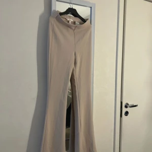 Beige vida byxor - Snygga beige byxor med hög midja och vida ben. Perfekta för en stilren look. Aldrig använd! 