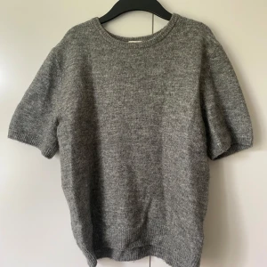 Kortärmad stickad tröja - Grå stickad tröja från hm i storlek S. Knappt använd och jättemjuk, lite nopprig men det märks knappt. Nypris 180kr