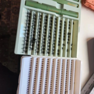 Sweetlux Cluster Lashes kit med lim - Säljer ett kit med Sweetlux Cluster Lashes i fem olika storlekar. Inkluderar två gröna tuber med lim och applikator. Fransarna är svarta och kommer i separata kluster för individuell applicering.