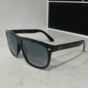 Svarta solglasögon från Ray-Ban - Klassiska svarta Ray-Ban Boyfriend solglasögon med Wayfarer-inspirerad form. Bågarna är i blank svart plast och glasen är mörktonade. Aldrig använda, och priset är inte hugget i sten så kom gärna med prisförslag!😊