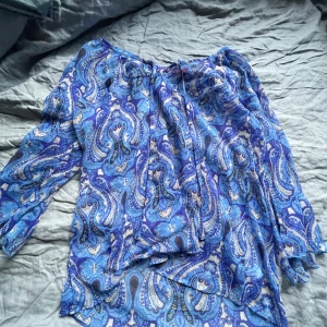 Blå blus med mönster  - En blå blus med unika mönster och lite genomskinligt material