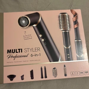 Multi Styler Professional 6-in-1 - En multifunktionell hårstyler med sex utbytbara tillbehör, inklusive rundborste, locktillbehör och fönmunstycke. Svart och guld design med digital display och flera värmeinställningar. Perfekt för att skapa olika frisyrer med ett enda verktyg.