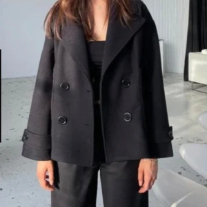 Svart designbysi kappa - Svart kappa från design ny si i storlek Xs, den är lite nopprig men i okej skick, nypris 757kr