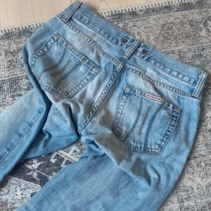 Ljusblå bootcut jeans från Fornarina - Jätte snygga ljusblå jeans från Fornarina Jeansen har låg midja lite slitna som man ser på sista bilderna men har sytt vid skrevet och de är inget som snyns när man har på sig dom midjemått tvärsöver är 33-34 cm och inerbenslängden är ca 77 cm
