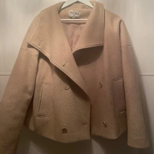 Kort kappa i beige - Använd men i bra skick. Enda är att den är knopprig en del.