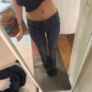 Mörkblå bootcut jeans - Snygga mörkblå jeans med bootcut passform och klassisk femficksdesign. Jeansen har normalhög midja och stängs med dragkedja och knapp. Perfekta till vardags för en avslappnad men stilren look. Storlek : 28:34