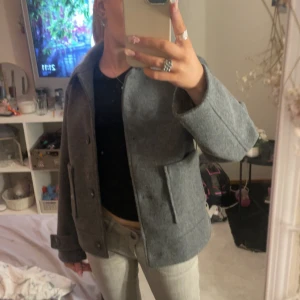 Grå kappa ifrån lager 157 - Säljer en grå jacka från lager 157. Jackan har knäppning framtill och två stora fickor. Perfekt för kyligare dagar och enkel att matcha med olika outfits. Säljer för att jag har en annan kappa och gillar inte riktigt hur denna sitter på mig☺️
