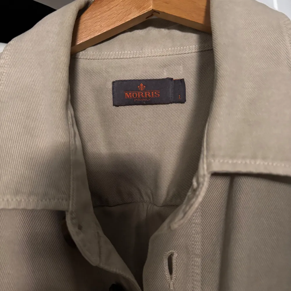 Säljer en stilren beige overshirt från Morris. Jackan har långa ärmar och knappar framtill samt två bröstfickor med knappar. Perfekt för en avslappnad look. Ord pris 2000sek. Takit.