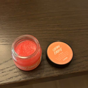 Snow Fairy Lip Mask från Lush - En läcker rosa läppmask från Lush med namnet Snow Fairy. Kommer i en liten burk med svart lock och har en söt doft. Perfekt för att återfukta och vårda läpparna.