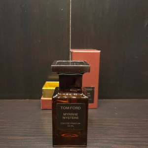 Tom Ford Myrrhe Mystère Eau de Parfum 50 ml - Elegant och mystisk doft från Tom Ford. Myrrhe Mystère kommer i en stilren brun flaska med en matchande kartong i rödbrun nyans. Perfekt för den som söker en unik och sofistikerad parfymupplevelse.