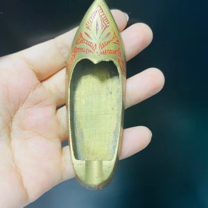 Vintage  Ashtray i mässing - En liten dekorativ sko i mässing med röda ingraverade mönster. Skon har en spetsig tå och är cirka 9 cm lång. Perfekt som prydnad eller samlarobjekt.