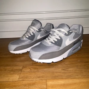Grå Nike Air Max sneakers - Snygga grå Nike Air Max sneakers med vit sula och snörning. Perfekta för en stilren look med sin klassiska design och bekväma passform.