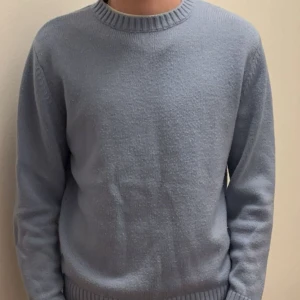 Ljusblå stickad tröja från Zara  - Säljer en stilren ljusblå stickad tröja med rund hals och ribbade kanter från zara . Perfekt för kyligare dagar och lätt att matcha med olika outfits. Passar både till vardag och mer avslappnade tillfällen.