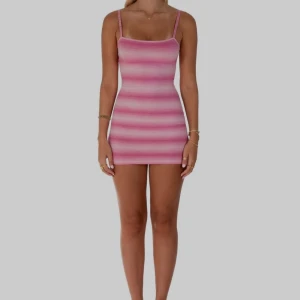 Rosa randig klänning från I Am Delilah - Snygg rosa randig klänning från I Am Delilah. Den är ärmlös med smala axelband och har en tight passform som framhäver figuren. Perfekt för en somrig look!