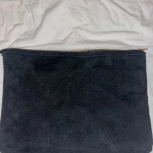 Svart datorväska i mocka - Säljer ännu en till elegant datorväska i mocka tyg. Väskan är perfekt för skolan eftersom den är stor vilket gör att det får plats med vilken dator som helst samt böcker. Väskan har en guld zip vilket gör att den får en elegant look! Priset kan diskuteras🥰💕