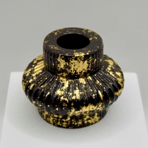 Svart och guld ljusstake i jesmonite - Denna unika ljusstake är handgjord av jesmonite och har en elegant svart finish med skimrande gulddetaljer. Dess strukturerade yta och lyxiga design gör den till en perfekt inredningsdetalj för både moderna och klassiska hem.  Höjd: 6,5 cm  Bredd: 8 cm