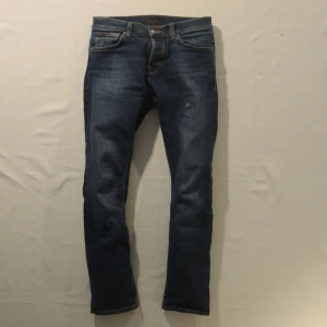 Nudie Grim Tim - Ett par riktigt schyssta jeans från Nudie med en snygg wash och i toppskick. Jeansen är perfekta till vardagen men kan även kläs upp med skjorta. Storleken är W:32 och L:34. Vid intresse är det bara att höra av sig!