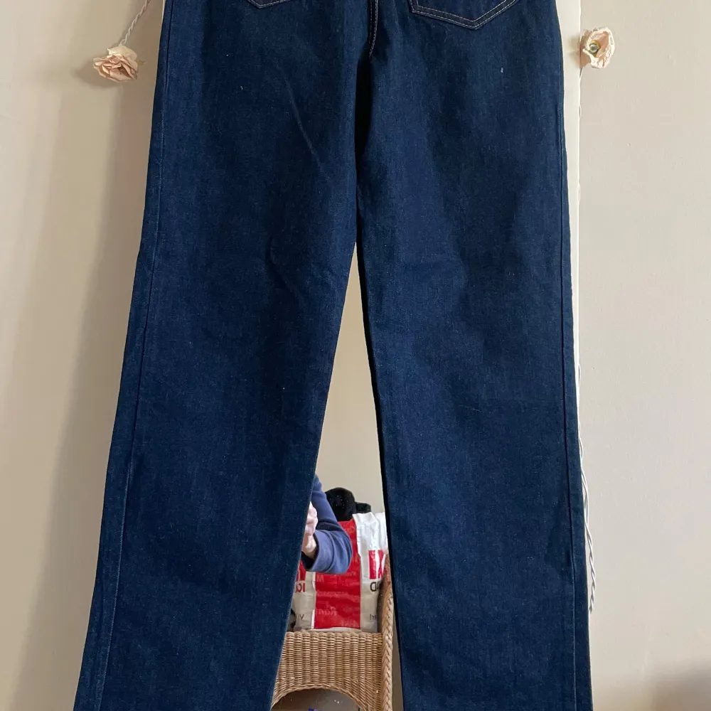 Snygga mörkblå jeansbyxor från Oggi med klassisk femficksdesign. Byxorna har en rak passform och är tillverkade i slitstarkt denim. Byxor är hög midja,storlek på midjan är ca 37cm . Längd från insidan av byxan är 87cm . Sidor av benen är 114cm .köpt år 2003 helt oanvänd.nypris 1600 kr . Jag vill ha 550kr.kan möta er i Stockholm utanför Åhléns i T-Central . Farkut & Housut.