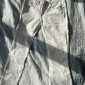 Vita jeansbyxor från Tommy Hilfiger - Snygga vita jeansbyxor från Tommy Hilfiger i straight fit. Byxorna har en klassisk design med fem fickor och knappgylf. Perfekta för en stilren look. W32L34