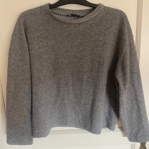 Grå långärmad tröja - Grå långärmad tröja från Zara, ser stickad ut men är av tjockare tyg, använd men i gott skick utan defekter