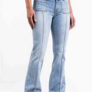 Ljusblå bootcut jeans med fickor - Snygga ljusblå jeans med bootcut passform och markerade sömmar längs benen. Framtill finns stora fyrkantiga fickor och baktill klassiska fickor med lock och knapp. Jeans från madlady. Storlek 32 och i längd regular. Köpta för 700kr ungefär, nån gång i februari men använda varsamt och därav inga defekter. Pris går att diskutera och skriv för fler bilder💕