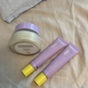 Budgie lip oil & mango face mask set - Säljer ett set från Budgie med två Glowy Hyaluronic lip oil treatment i lila tuber med gula korkar och en Nourishing Mango Butter melting overnight face mask i glasburk med lila lock. Veganska produkter med återfuktande och mjukgörande egenskaper.