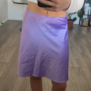 Satin kjol - Lila satinkjol med dragkedja i sidan.