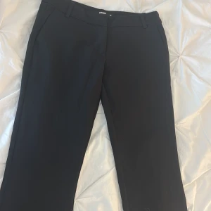 Svarta kostymbyxor från BikBok - Lågmidjade svarta kostymbyxor från bikbok. Inte jätte använd men lite sönder vid hälen då de varit för långa. Köpta för 500kr i butik.
