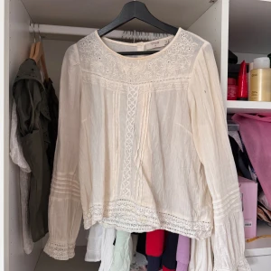 Krämvit blus med spets från Cream - Romantisk krämvit blus från Cream med broderade spetsdetaljer. Knappt använd men köpt länge sen. Nypris 700