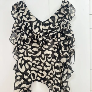 Leopardmönstrad linnetopp från Zara - Säljer en snygg leopardmönstrad linnetopp från Zara med volangdetaljer och tunna axelband. Helt ny med prislapp kvar! Hör av dig om du har frågor💗
