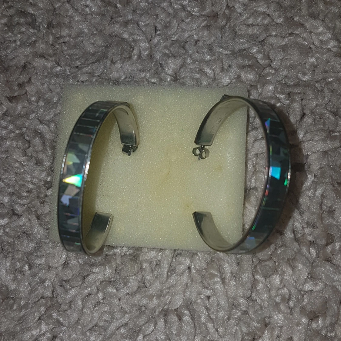 Stora silvriga örhängen med glittrig yta