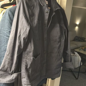 Blå overshirt från Lindbergh - Snygg blå overshirt från Lindbergh med fyra stora fickor framtill och klassisk krage. Jackan har knäppning med knappar hela vägen och är tillverkad i ett mjukt bomullsmaterial. Perfekt för lager-på-lager och enkel att styla till olika outfits. Mycket bra skick!