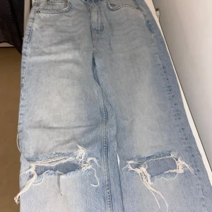 Ljusblå ripped jeans straight fit - Säljer ett par ljusblå jeans med raka ben. Jag har knappast använt dessa jeans endast 2 gånger sedan dem köptes, dem har alltid varit i garderoben och  ni tänkte jag rensa oxh byta still. Väldigt fina jeans överlag och dessa är i storlek 32. 
