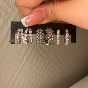 Set med silvriga örhängen med stenar - Säljer ett set med 3 par silvriga örhängen i olika designer. Perfekta för att ha tillsammans. Väldigt fint skick!🥰🙏🏼