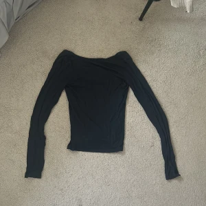 Svart långärmad topp från 157 - En mörkblå långärmad topp från 157 i storlek XS. Tröjan har öppen rygg och är ett stretchigt material, perfekt för att styla med jeans eller kjol. Enkel och stilren. Säljer eftersom den inte kommer till användning 