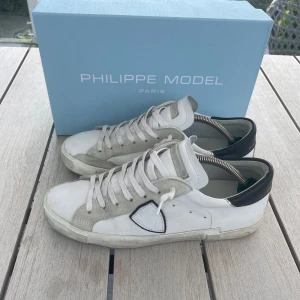 Philippe Model skor - Säljer nu dessa snygga vita sneakers från Philippe Model med grå mockadetaljer och svart häl | Storlek 42 | De är i använt men bra skick! | Nypris 3900kr, mitt pris 2100kr! Allt og medföljer | Hör av dig vid eventuella frågor!