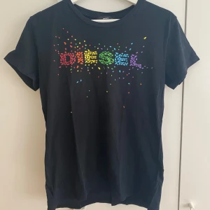 Svart t-shirt med regnbågslogo från Diesel - Svart t-shirt från Diesel med färgglad regnbågsfärgad logga framtill. Mycket bra skick!