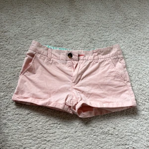 Ljusrosa lågmidjade shorts  - !Öppen för bud!                                                      Söta rosa shorts från Holly & Whyte by Lindex. Klassisk modell med fickor fram, bälteshällor och knappstängning. Perfekta att ha på sig med ett vitt linne eller blus🩷
