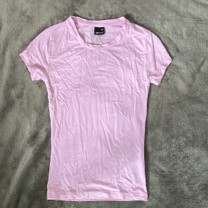 Ljusrosa t-shirt från Gina Tricot - Säljer en basic ljusrosa t-shirt från Gina Tricot i storlek XXS. Endast använd en gång. T-shirten har rund halsringning och korta ärmar, otroligt mjukt och skönt material. Perfekt att styla med jeans eller kjol för en clean look. Säljer även en likadan i vit! Skriv vid fler frågor!!💓💓