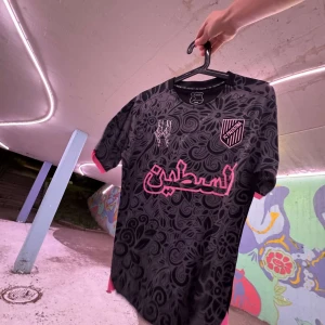 FC Palestina Svart/Rosa - 🎁 Vid varje köp får du ett armband + slumpmässigt klistermärke som tack från oss. Vi står tillsammans för Palestina. 🇵🇸 