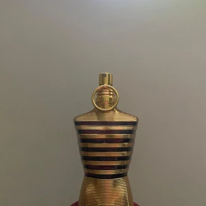 Le Male Elixir Jean Paul Gaultier 125ml - Le Male Elixir från Jean Paul Gaultier är en herrparfym i en ikonisk bystformad flaska med guld- och bronsfärgade ränder. Doften har tydliga inslag av vanilj, sötma, honung, lavendel och amber. Flaskan rymmer 125 ml och har en lyxig metallfinish.