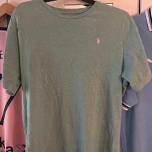 Grön t-shirt från Polo Ralph Lauren - Snygg grön t-shirt från Polo Ralph Lauren med klassisk passform och liten broderad logga på bröstet. Tillverkad i mjuk bomull och har rund halsringning samt korta ärmar. Perfekt för en chill och stilren look. XL i barn storlek passar mig M/L