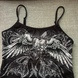 Svart linne med vingar - .